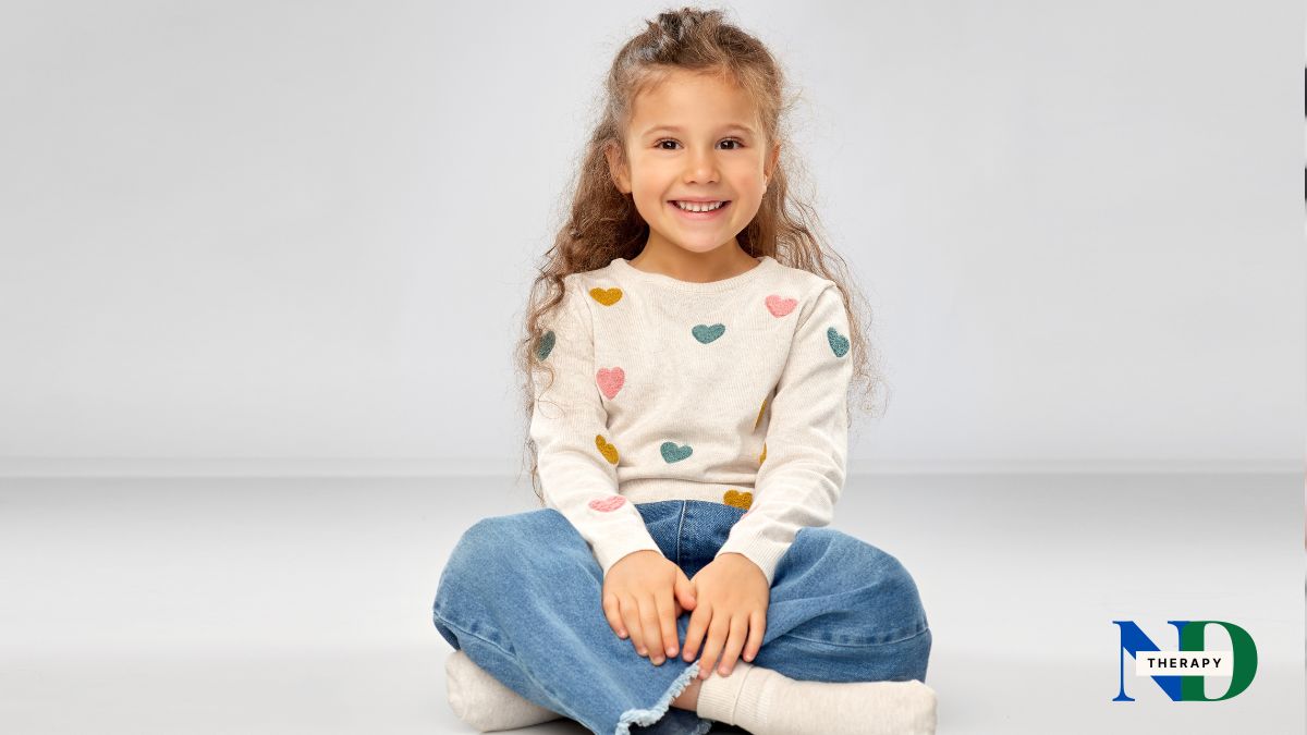 A young girl sitting, smiling.
