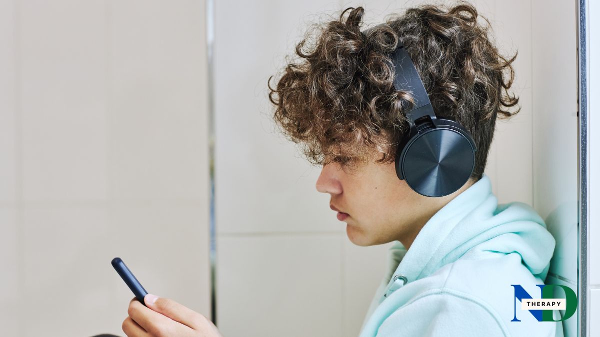 boy-headphones-phone Boy wearing headphones looking at phone.