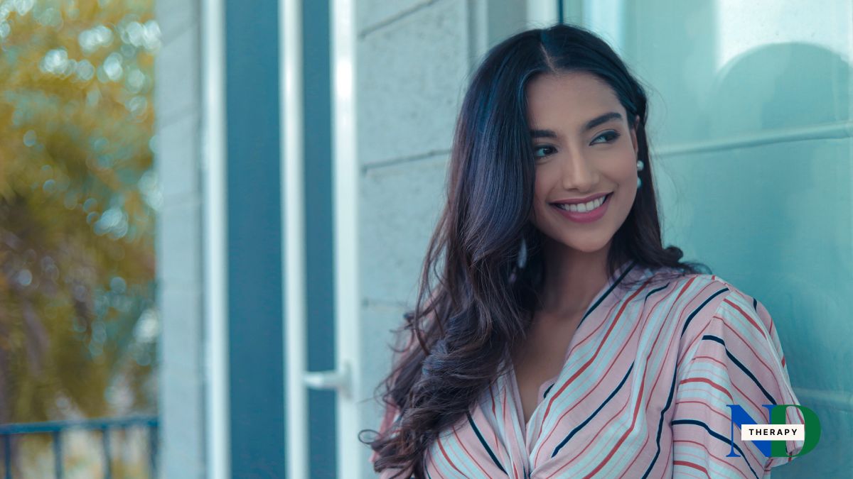 woman-smiling-blue-house-background A smiling woman on a blue background.
