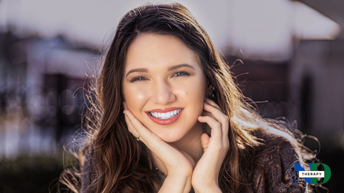 woman-smiling-long-hair-dark-background Woman with long hair smiling.