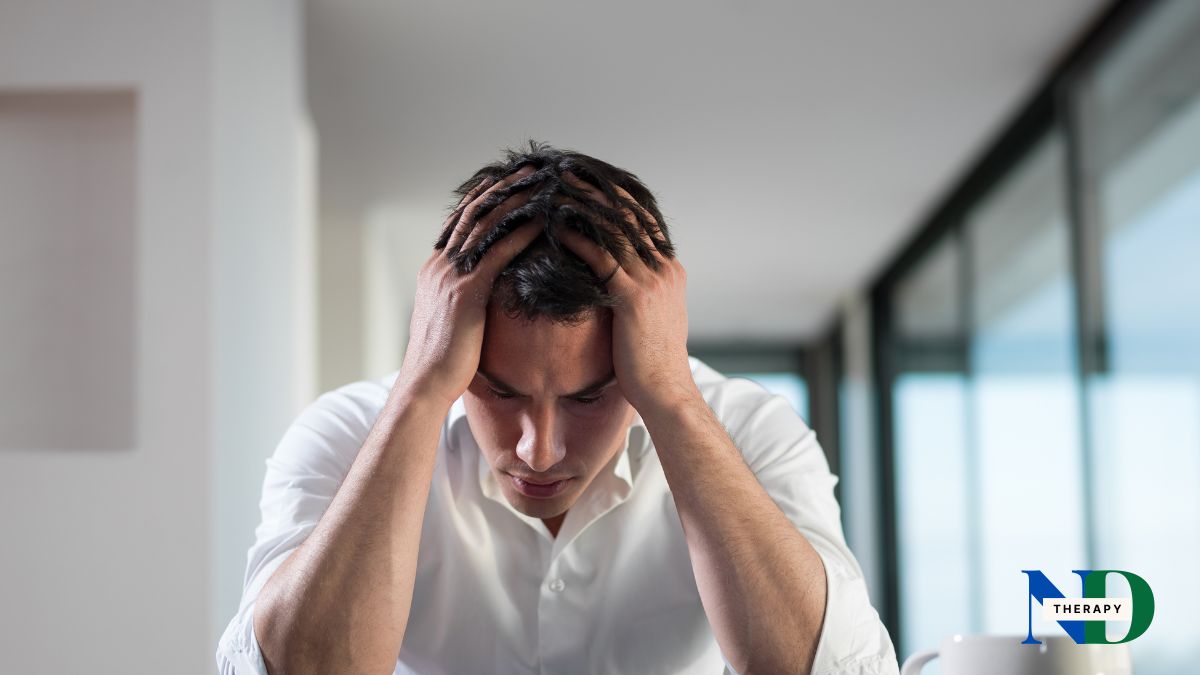 A man wearing a white shirt is upset.