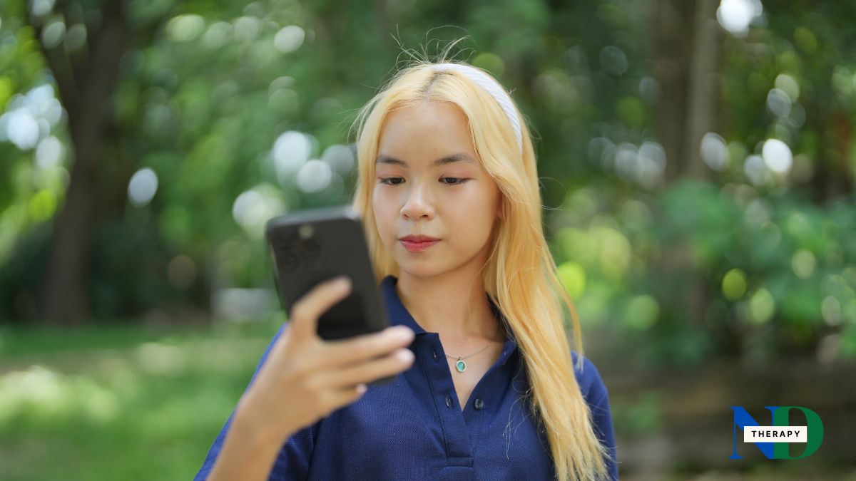 Blond Asian teen looking at her phone.
