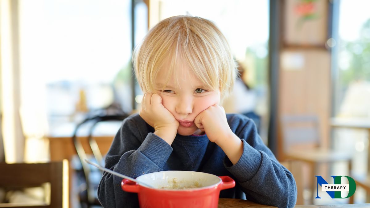 A child eating soup, sad.