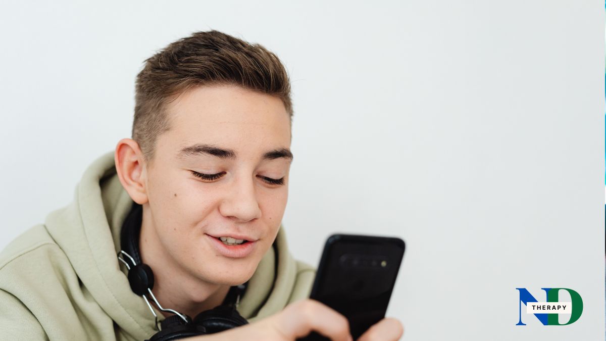 A teen with a smartphone, smiling.