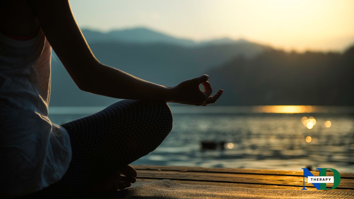 A woman meditating with a calm background.