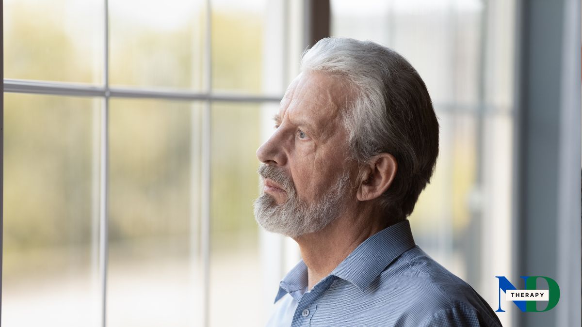 An older man looking through a window.