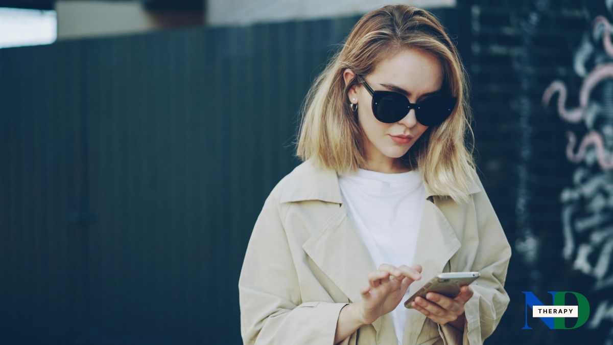 Adult woman wearing sunglasses checks her smartphone.