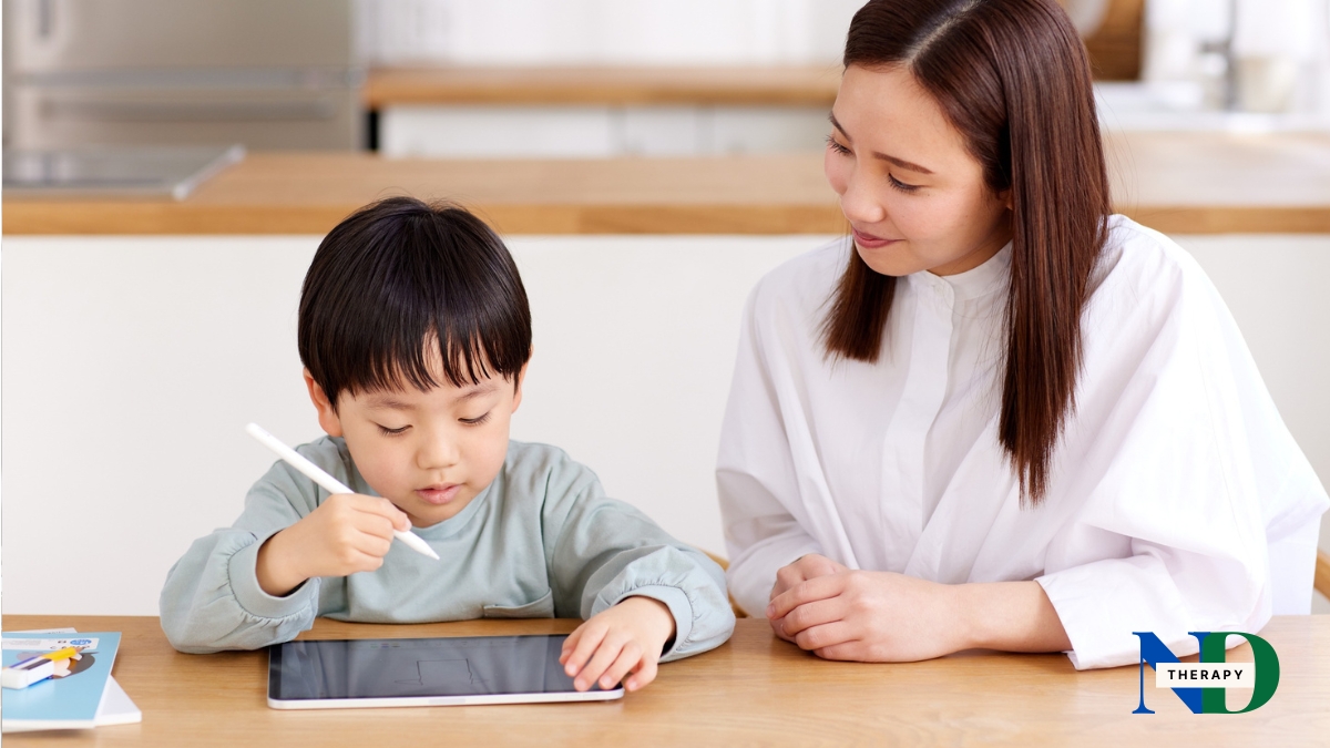 A mother stays calmly beside her son as he uses a tablet, modeling support rather than restriction.