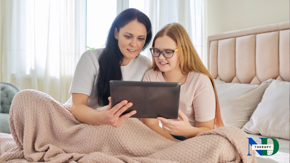 Parent and teen sitting together looking at a tablet, discussing gaming limits.